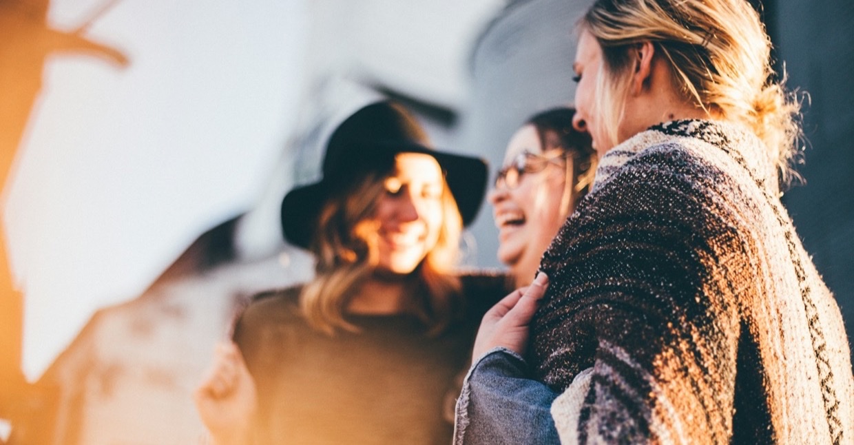 Drie lachende vrouwen in de zon