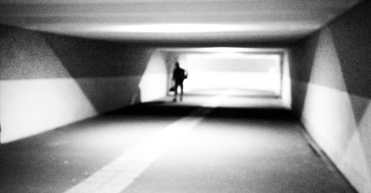 Persoon loopt door een verlichte voetgangerstunnel